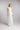 Brautkleid FLORA, Frontansicht mit drapiertem One‑Shoulder Oberteil aus Seidenchiffon und abnehmbarer Blüte aus Organza an der Schulter.