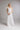 Brautkleid FLORA, Frontansicht mit drapiertem One‑Shoulder Oberteil aus Seidenchiffon und abnehmbarer Blüte aus Organza an der Schulter.