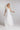 FLORA One‑Shoulder Brautkleid in Bewegung, fließender, bodenlanger Seidenchiffon‑Rock mit großer Blütendetail‑Schulter.
